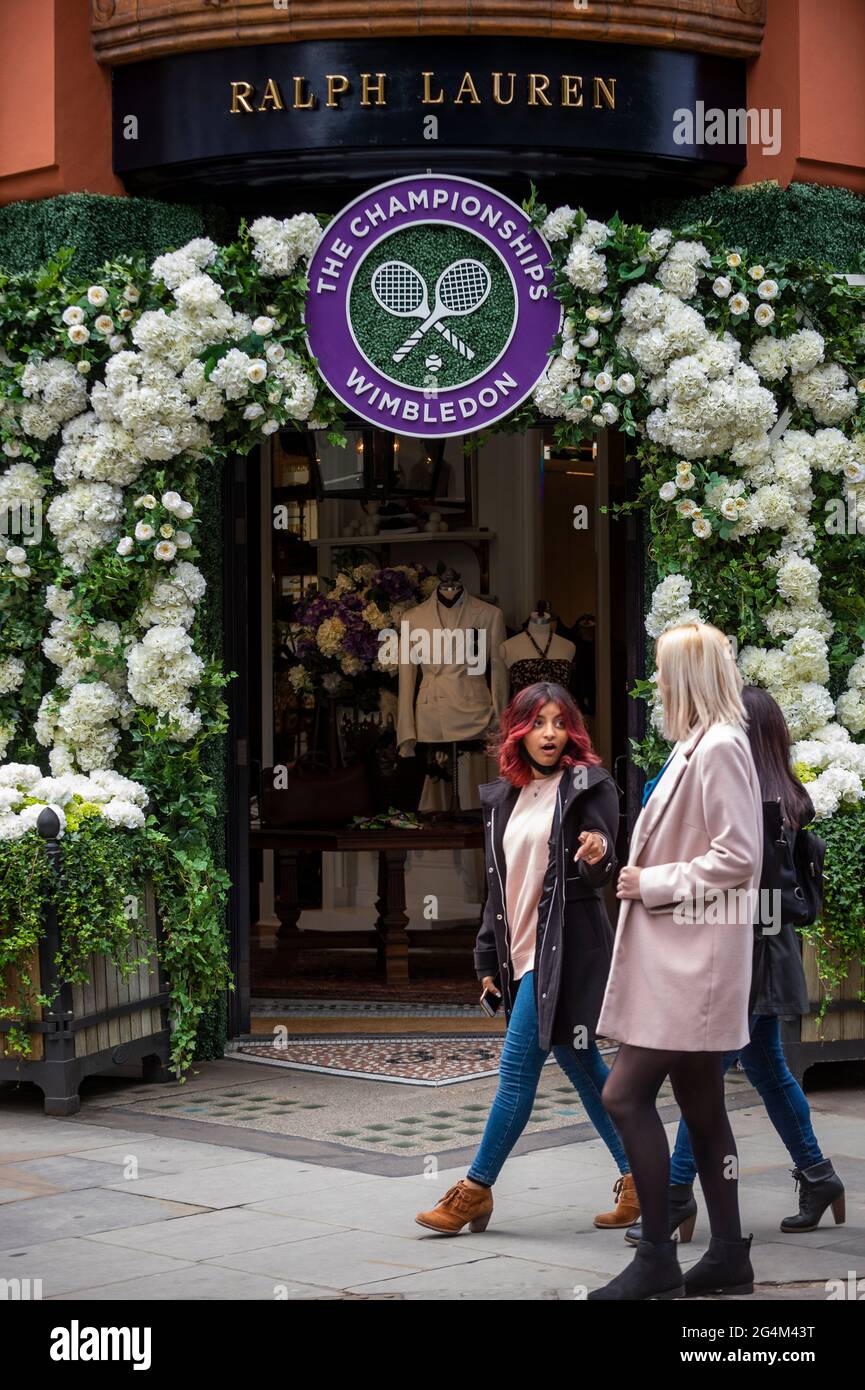 London, Großbritannien. 22. Juni 2021. Die Menschen gehen an der Außenfassade des Ralph Lauren-Ladens am Sloane Square vorbei, der vor den kommenden Wimbledon-Tennismeisterschaften im All England Club dekoriert wurde. Ralph Lauren liefert den Beamten bei der Veranstaltung Outfits. Lockdown-Beschränkungen werden die Menge begrenzen, aber das Finale wird voll ausgelastet sein, wenn die Einschränkungen gelockert werden. Kredit: Stephen Chung / Alamy Live Nachrichten Stockfoto