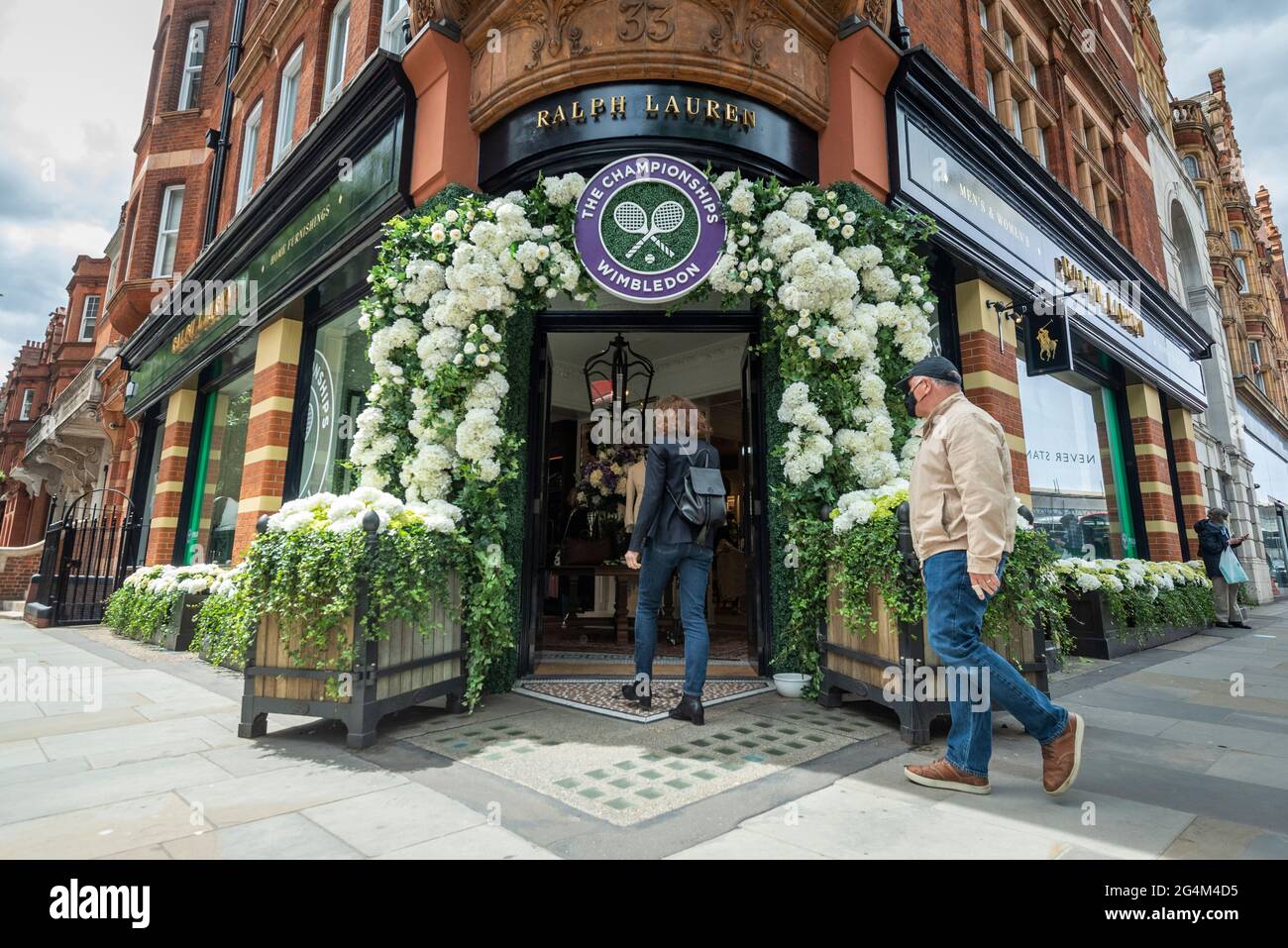 London, Großbritannien. 22. Juni 2021. Menschen betreten den Ralph Lauren-Laden am Sloane Square, der vor den kommenden Wimbledon-Tennismeisterschaften im All England Club dekoriert wurde. Ralph Lauren liefert den Beamten bei der Veranstaltung Outfits. Lockdown-Beschränkungen werden die Menge begrenzen, aber das Finale wird voll ausgelastet sein, wenn die Einschränkungen gelockert werden. Kredit: Stephen Chung / Alamy Live Nachrichten Stockfoto