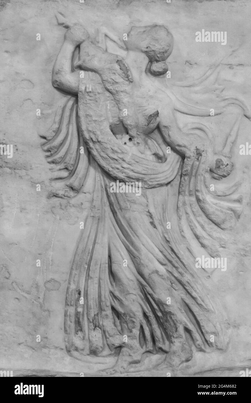 Schwarzweiß-Foto in Nahaufnahme einer antiken Illustration, die auf einer Marmorwand geschnitzt ist und eine Frau zeigt, die ein totes Kaninchen trägt Stockfoto