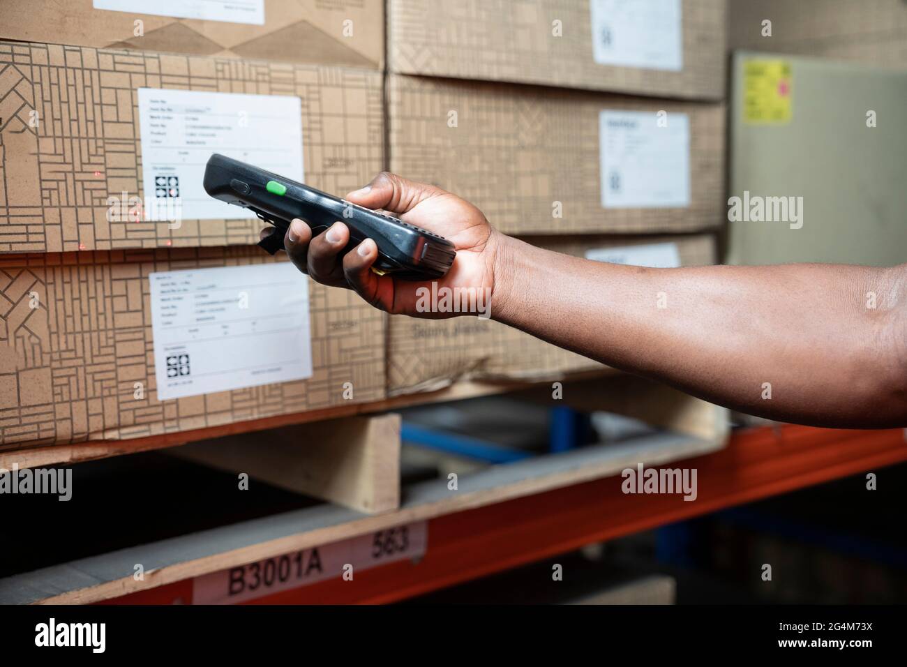 Lagerarbeiter, der mit einem Scanner die Ladung in den Regalen überprüft. Stockfoto