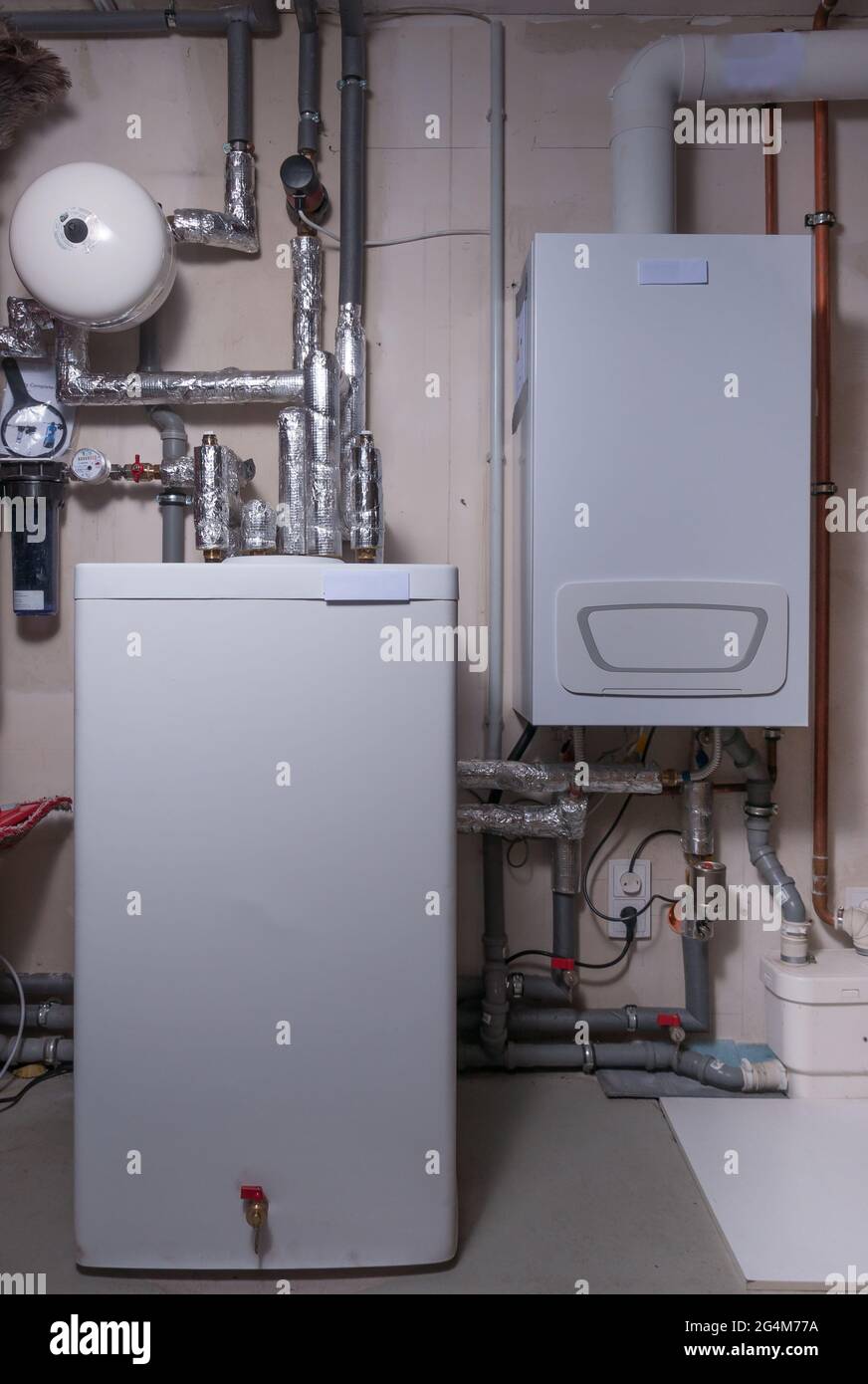 Neu erbautes Heizsystem mit thermischem Speicher und Expansionstank. Installiert im Keller eines Familienhauses Stockfoto