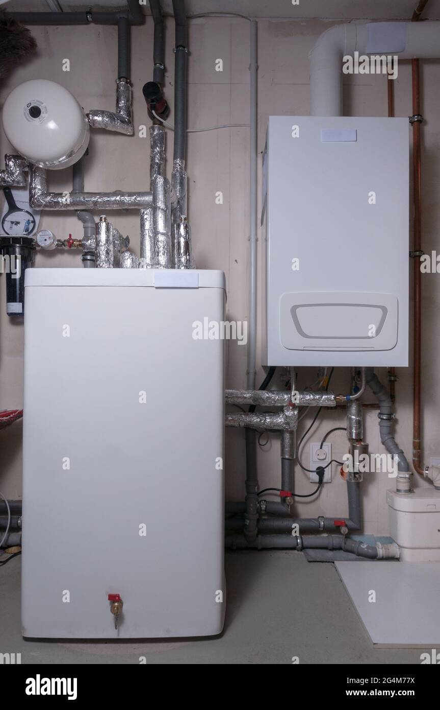 Neu erbautes Heizsystem mit thermischem Speicher und Expansionstank. Installiert im Keller eines Familienhauses Stockfoto