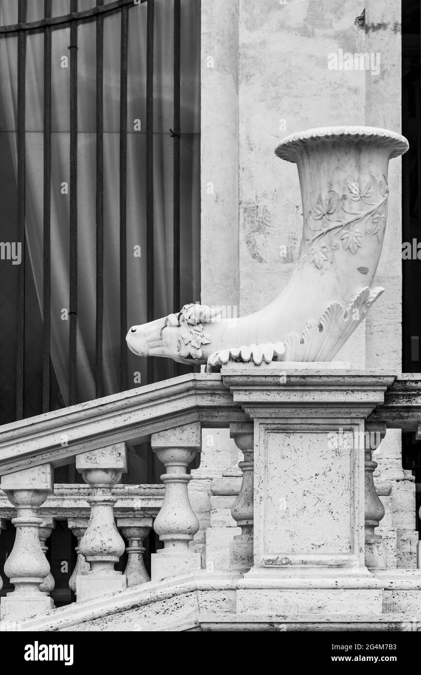 Schwarz-Weiß-Foto des alten Marmorhorns, das einen Gebäudeeingang in Rom schmückt Stockfoto