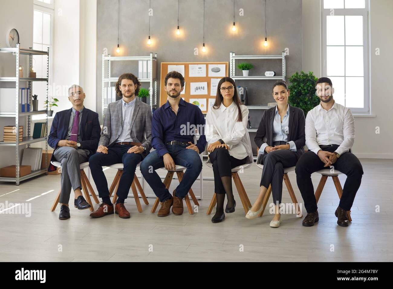 Gruppenporträt von Personen, die während eines Geschäftstreffens oder einer Lehrveranstaltung in Reihe sitzen Stockfoto