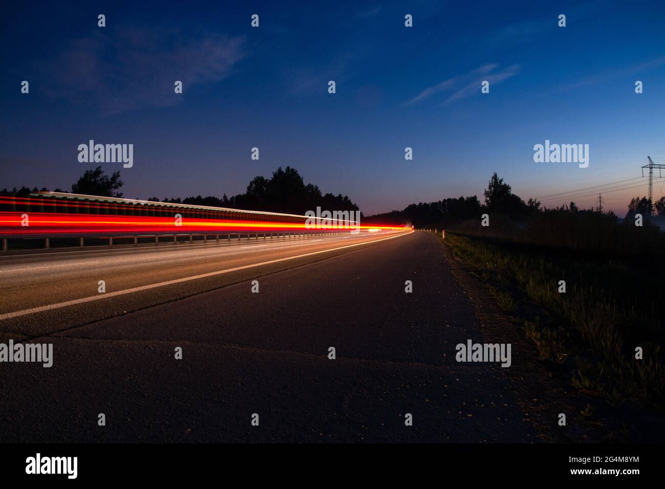 Nachtspur mit verschwommenem Licht von den Scheinwerfern von Autos.lange Belichtungszeit Stockfoto