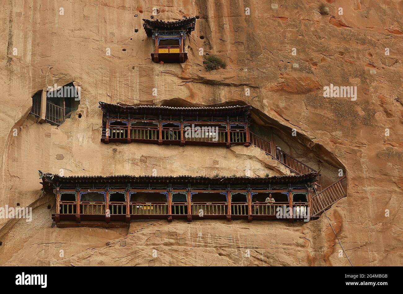 Wangye, China. Juni 2021. Touristen besuchen die Tempelgrotten in der Nähe von Wangye, nordwestlich der Provinz Gansu, am Sonntag, den 20. Juni 2021. Der alte Tempel ist eine geschützte tibetisch-buddhistische Stätte. Der Tourismus in der Provinz Gansu, dem siebtgrößten Verwaltungsbezirk Chinas, macht fast die Hälfte des Jahresumsatzes der Provinz aus und bleibt eine der ärmsten Provinzen des Landes. Foto von Stephen Shaver/UPI Credit: UPI/Alamy Live News Stockfoto