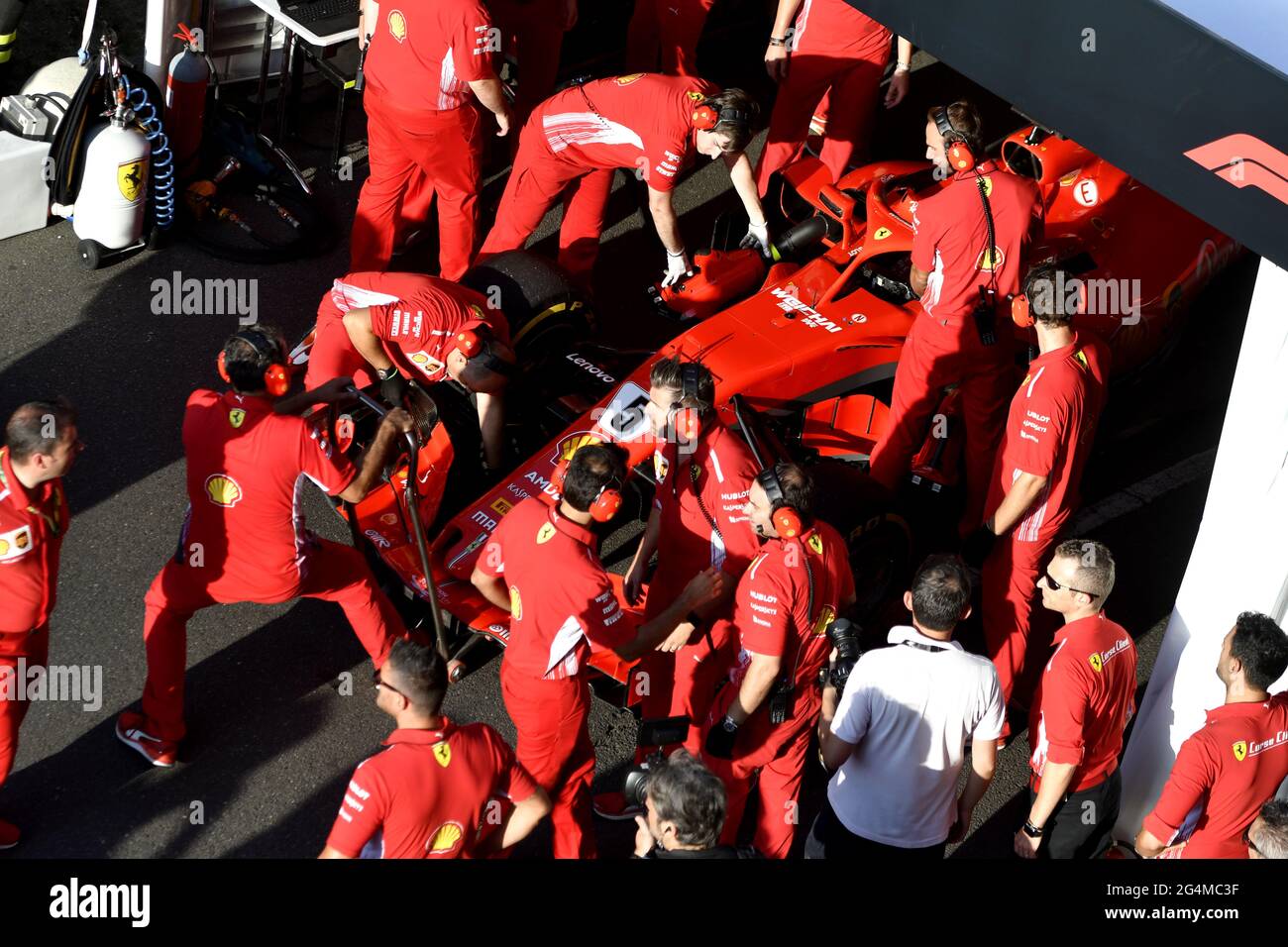 Die Boxenstoppmannschaft von Ferrari, die während einer Ausstellung in Mailand, Italien, um den Ferrari Formel 1 an der Box von Ferrari herum arbeitet. Stockfoto