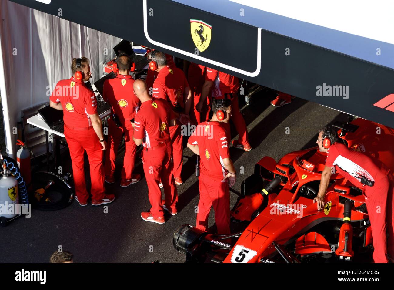 Die Boxenstoppmannschaft von Ferrari, die während einer Ausstellung in Mailand, Italien, um den Ferrari Formel 1 an der Box von Ferrari herum arbeitet. Stockfoto