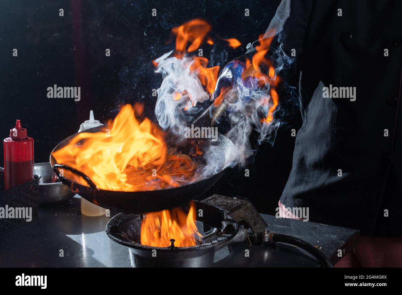 Flambe Bratpfanne Wok, Kochen auf Feuer. Panasiatische Küche. Street Food. Stockfoto
