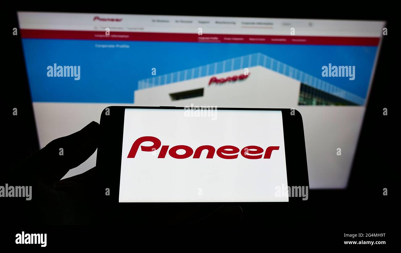 Person, die Smartphone mit Logo des japanischen Elektronikunternehmens Pioneer K.K. auf dem Bildschirm vor der Website hält. Konzentrieren Sie sich auf die Telefonanzeige. Stockfoto