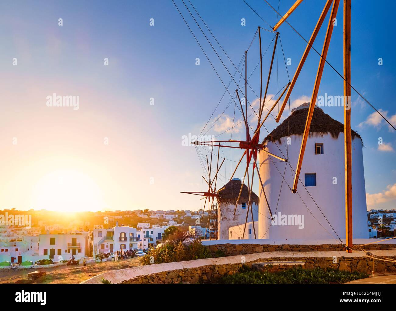 Berühmte Touristenattraktion von Mykonos, Griechenland. Traditionelle weißgetünchte Windmühlen in Reihe gegen die Sonne. Sommer, Sonnenaufgang, Reiseziel, ikonische Aussicht. Stockfoto