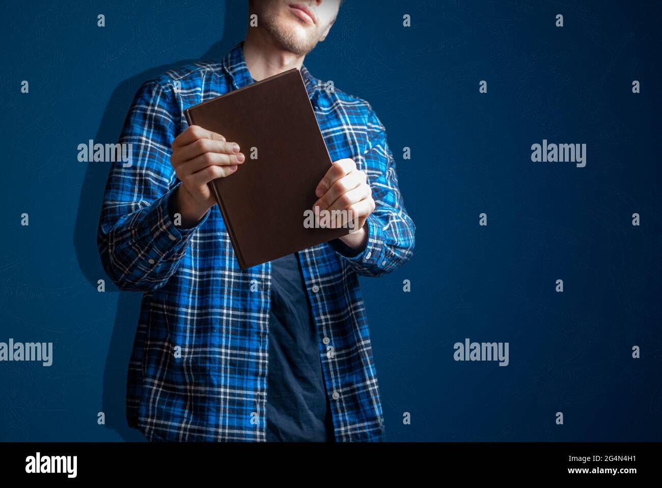 Junge Person hält und gibt ein Buch, Wissen und Weisheit zu teilen Stockfoto