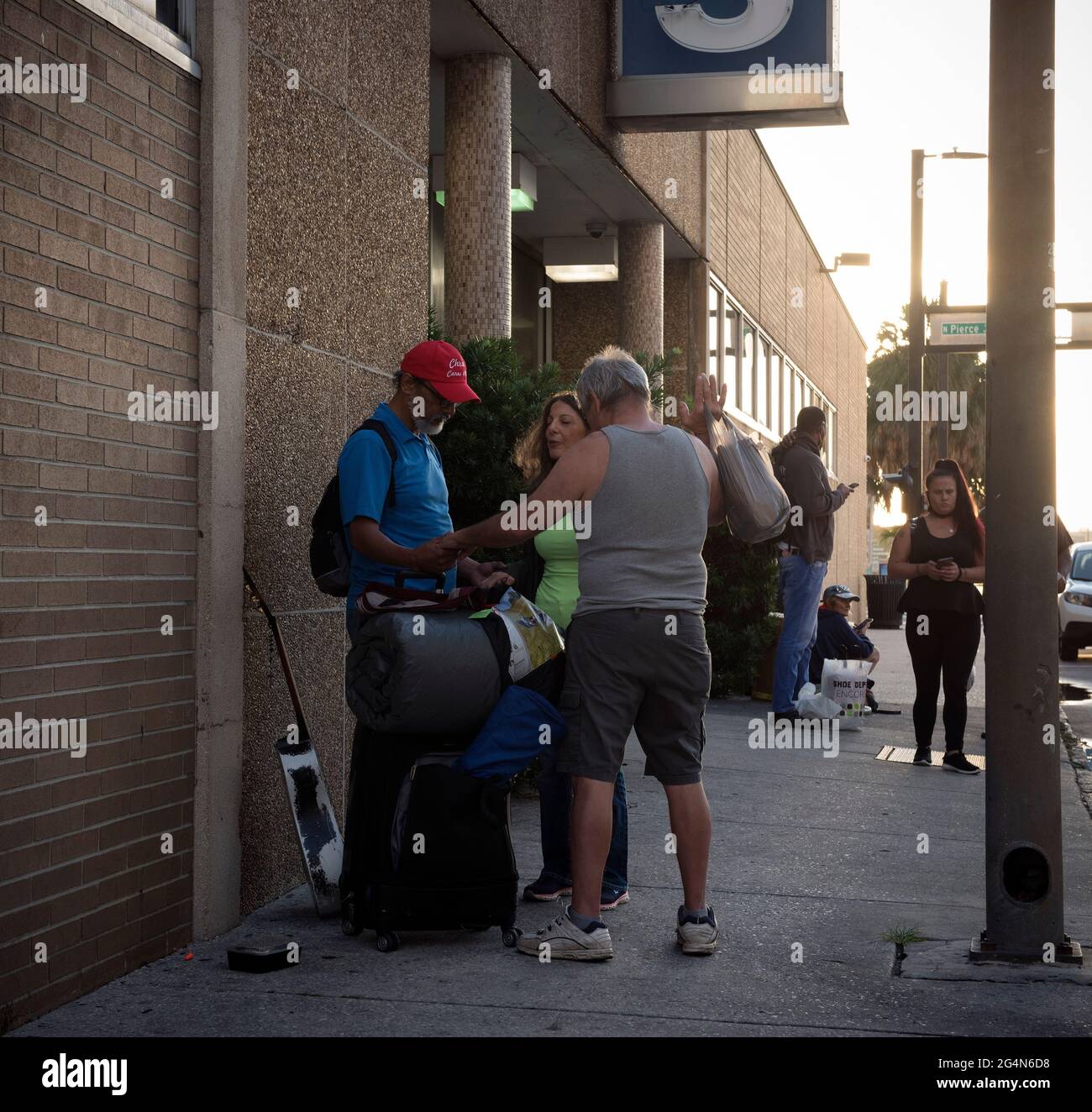 Zephyrhills, Florida, USA. Juni 2021. Maria Rapoza und ihr Mann Dennis Celentano beten mit einem Obdachlosen vor dem Greyhound-Busbahnhof in der Innenstadt von Tampa. Quelle: Robin Rayne/ZUMA Wire/Alamy Live News Stockfoto