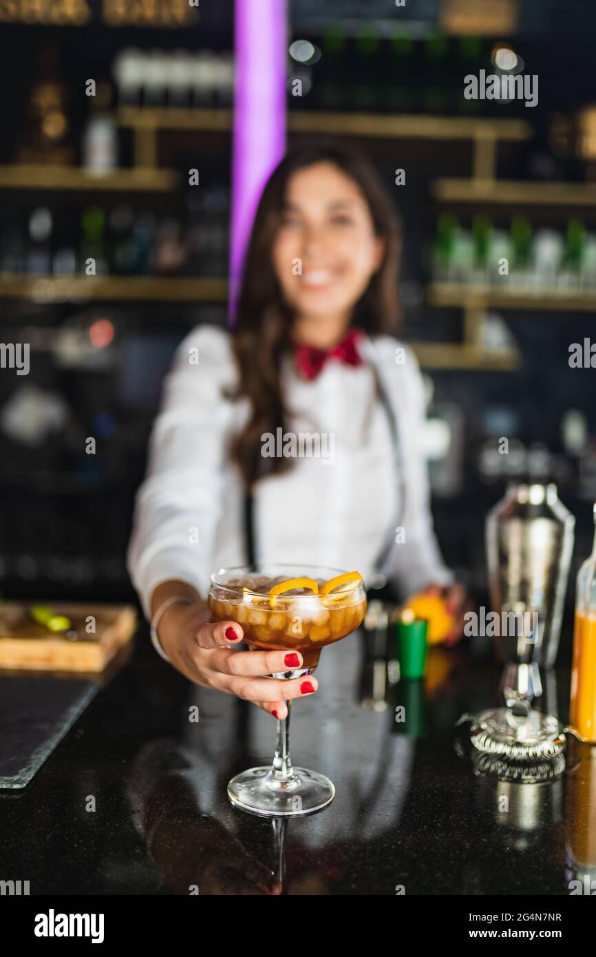 Ganzkörper-Seitenansicht aktiver Frauen, die auf dem Skateboard springen, während sie während des Trainings in der Stadt Stunt auf dem Sportplatz durchführen Stockfoto
