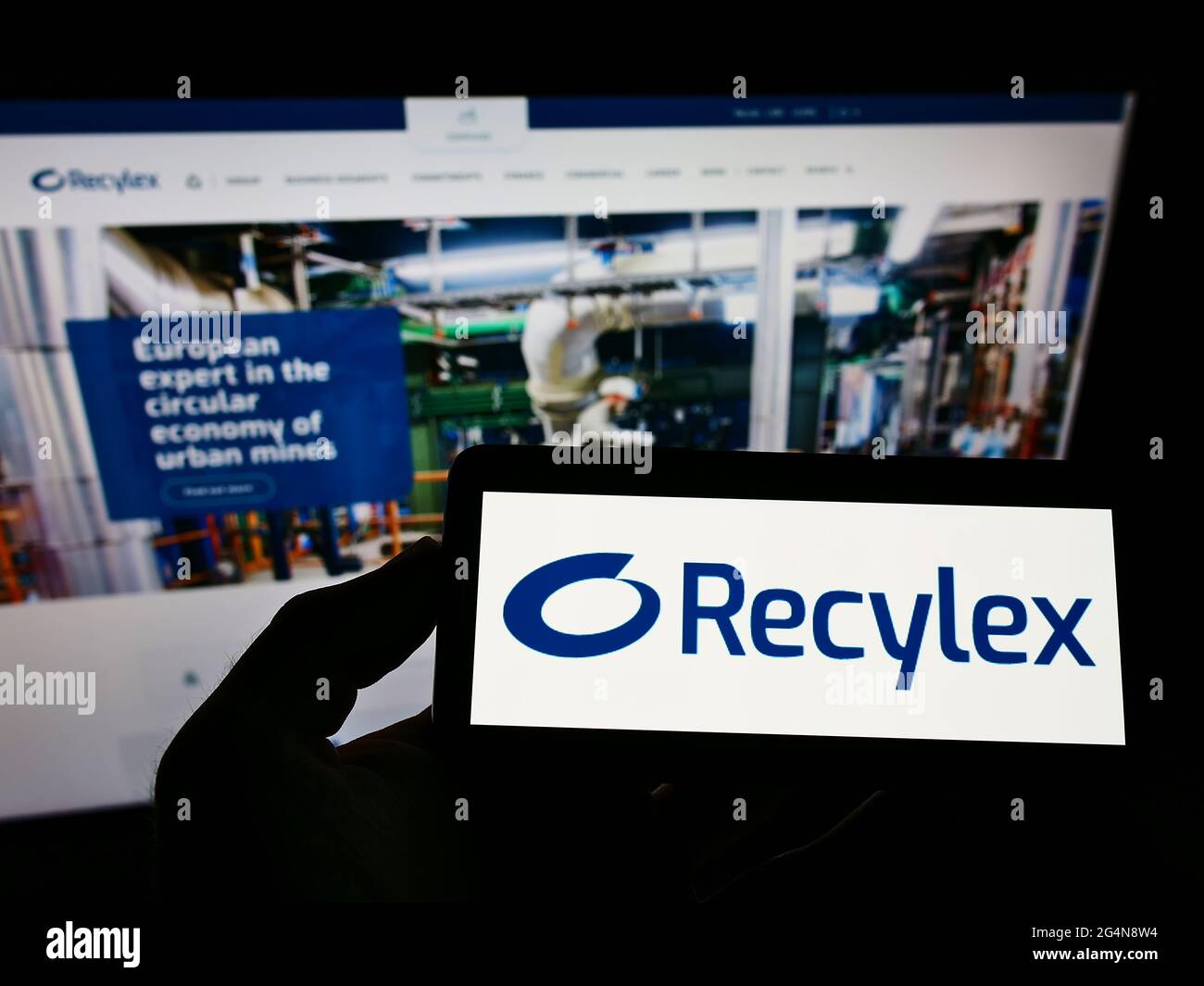 Person, die das Smartphone mit dem Logo des französischen Recyclingunternehmens Recylex S.A. auf dem Bildschirm vor der Website hält. Konzentrieren Sie sich auf die Telefonanzeige. Stockfoto