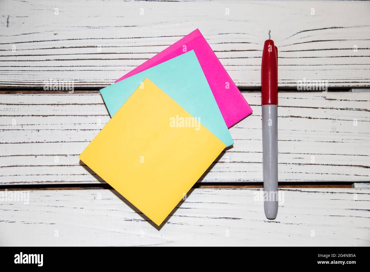 Bunte rosa und blau und gelb Stick auf Noten und ein Markt auf einem weißen Brett Hintergrund - flach legen Stockfoto