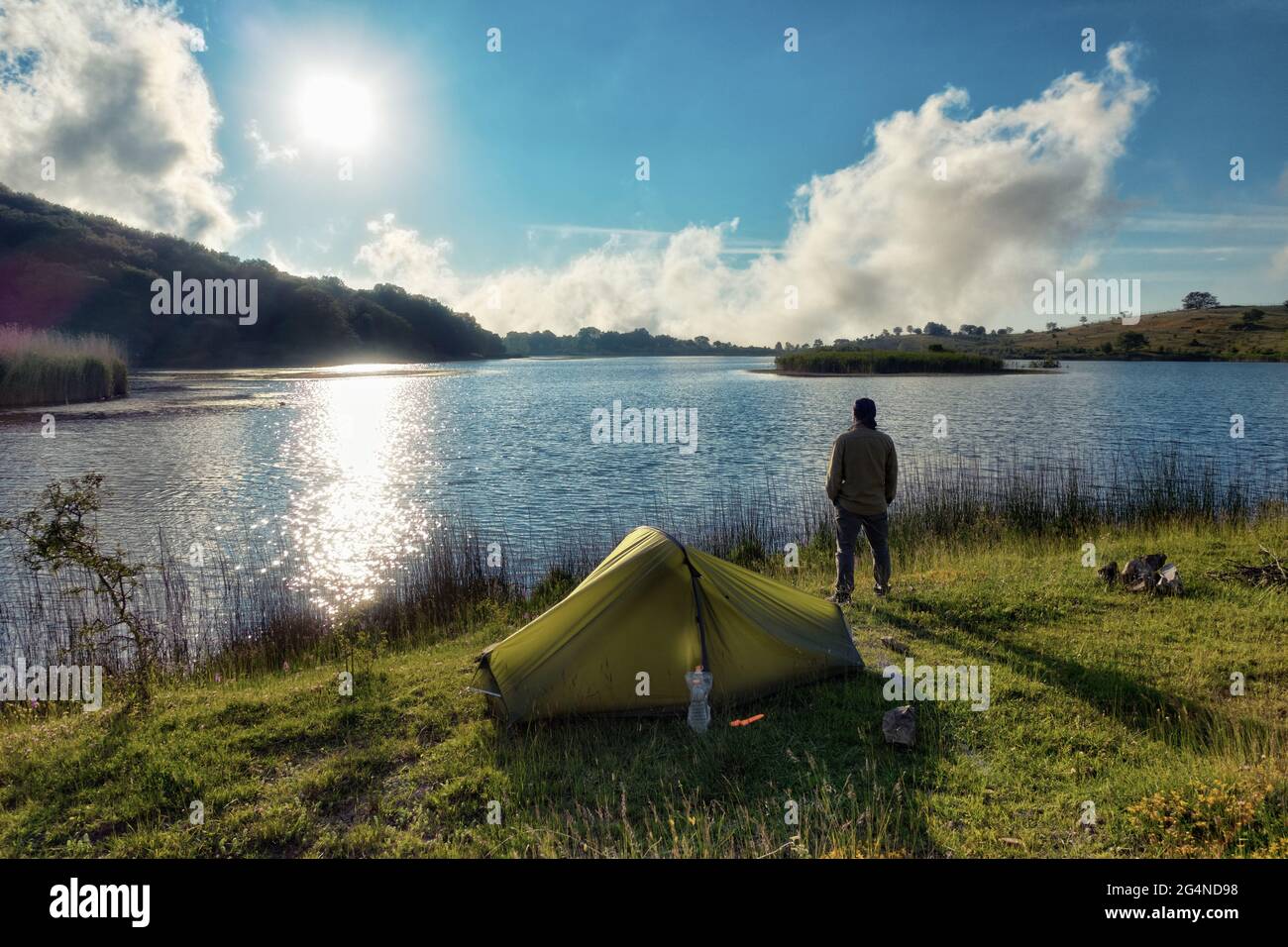 Ein Mann in der Nähe des Zeltes am See mit Blick auf die Idylle Siziliens im Naturschutzgebiet Nebrodi Stockfoto