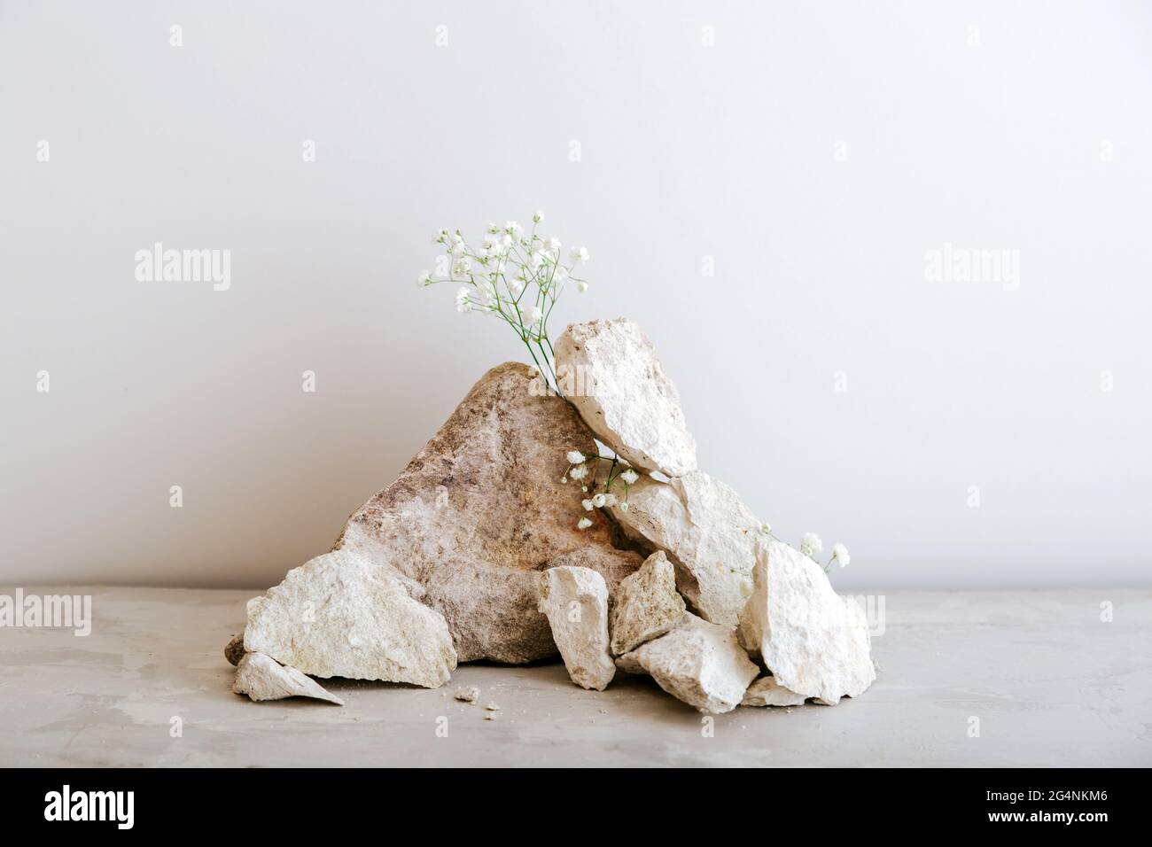 Leere graue Steine Turm Podium. Stones Podest Display auf beigefarbenem Beton Hintergrund aus Steinen Blumen Modell für Produktpräsentation. Stockfoto