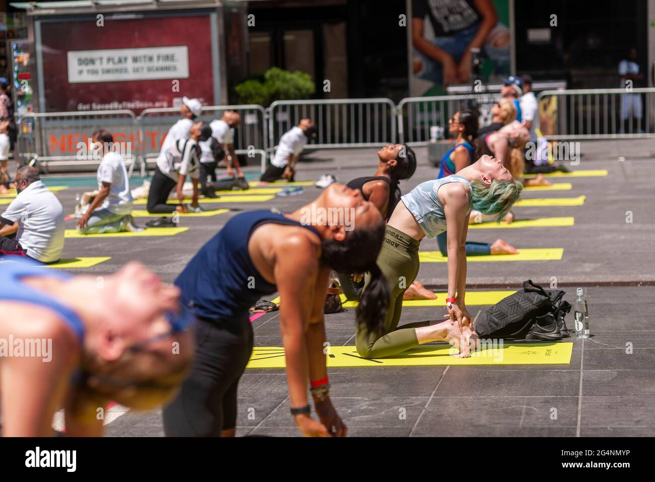 Sozial ferne Yogapraktiker packen den Times Square in New York ein, um am ersten Sommertag, Sonntag, 21. Juni 2021, Yoga zu praktizieren. Die jährliche Sonnenwende am Times Square, „Mind over Madness“, gesponsert von Ayrie, dem Generalkonsulat von Indien, New York und SmartWater, dehnt die Fähigkeit der Yogis aus, den Lärm und das visuelle Durcheinander, das sie an der Kreuzung der Welt umgibt, zu blockieren. Der erste Sommertag wurde von den Vereinten Nationen zum Internationalen Tag des Yoga erklärt. (© Richard B. Levine) Stockfoto