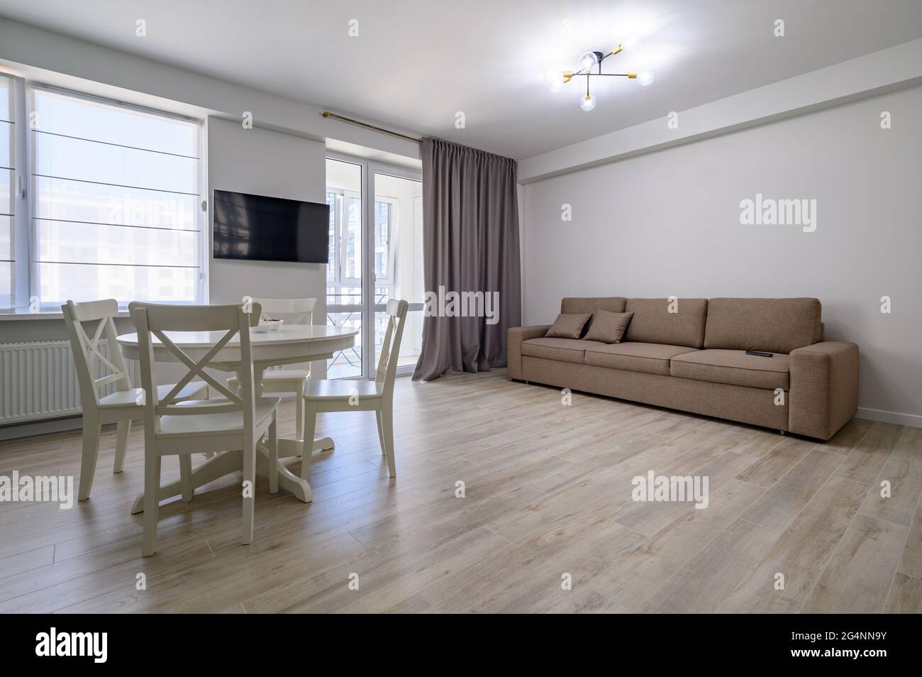 Ess- oder Wohnzimmer mit weißem runden Esstisch und Sofa Stockfoto