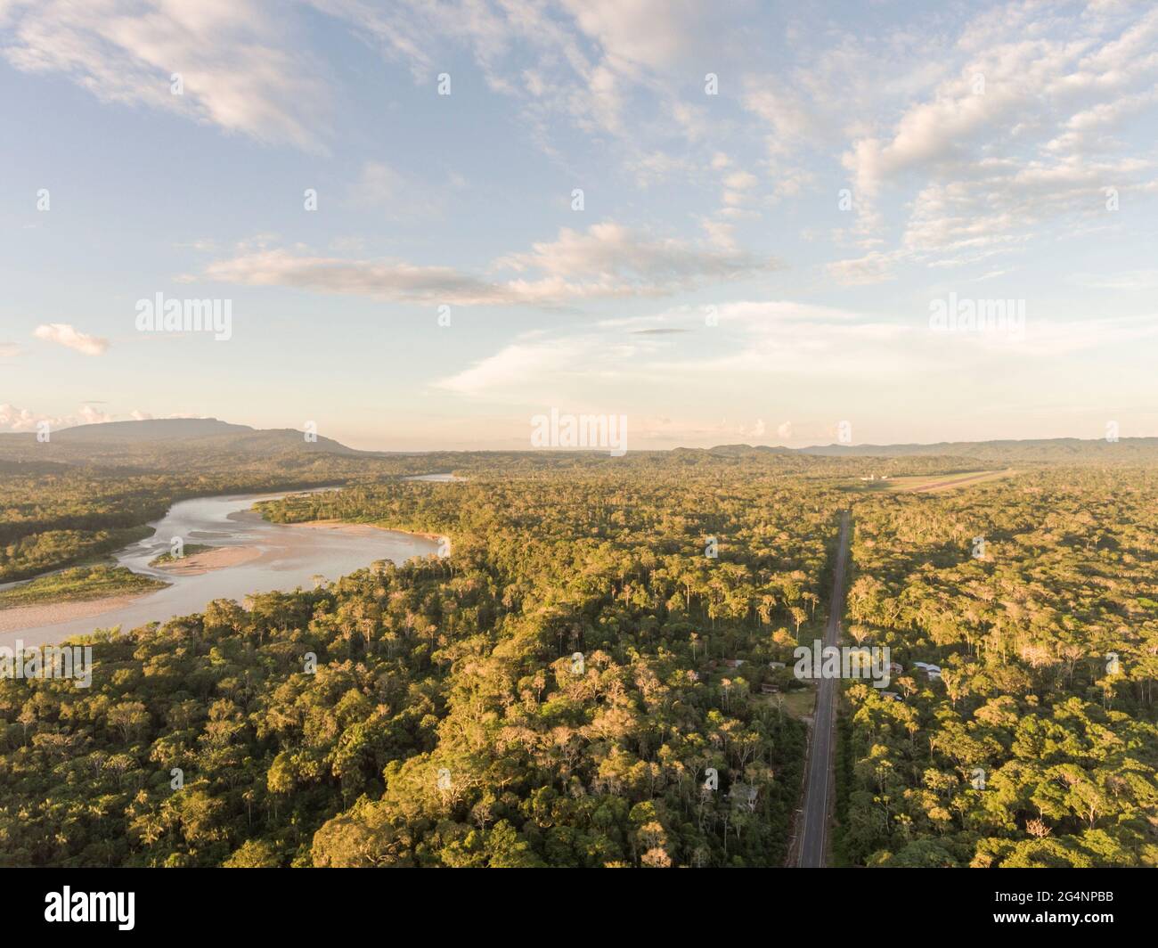 Luftaufnahme einer Autobahn des Amazonas in Ecuador mit Rio Napo und dem Berg Galeras im Hintergrund. Straßen bringen Kolonisierung und Zerstörung der Stockfoto