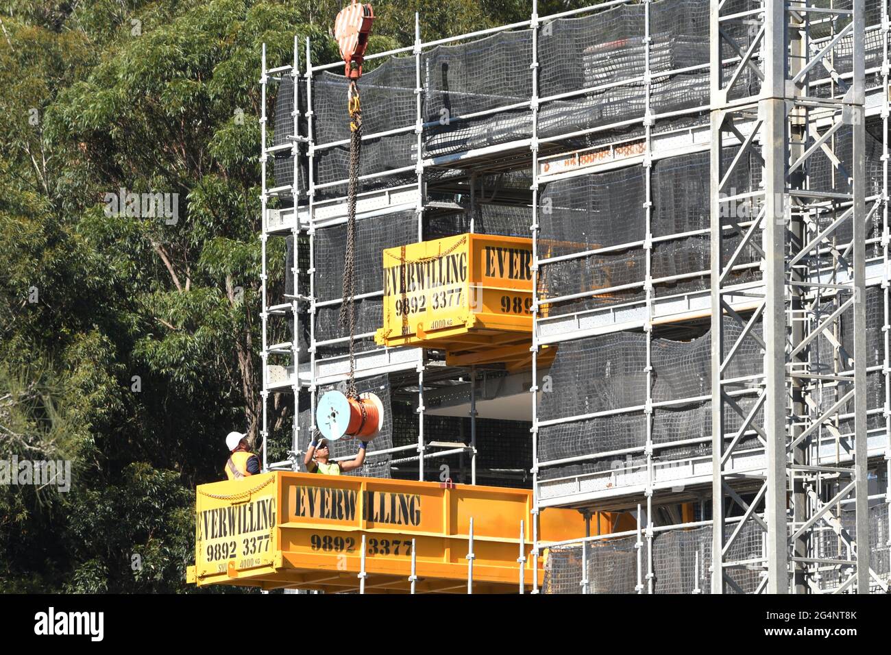 Australia, Gosford, 18. Mai 2021. Arbeiter, die die Ausrüstung auf dem neuen sozialen Wohnungsbau in der 56-58 Beane St. entladen, haben einen Teil eines Gebäudegebäudes gebaut Stockfoto