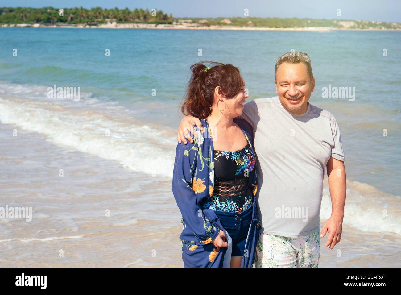 Ein älteres Paar, das im Sommer am Strand spazieren ging. Stockfoto