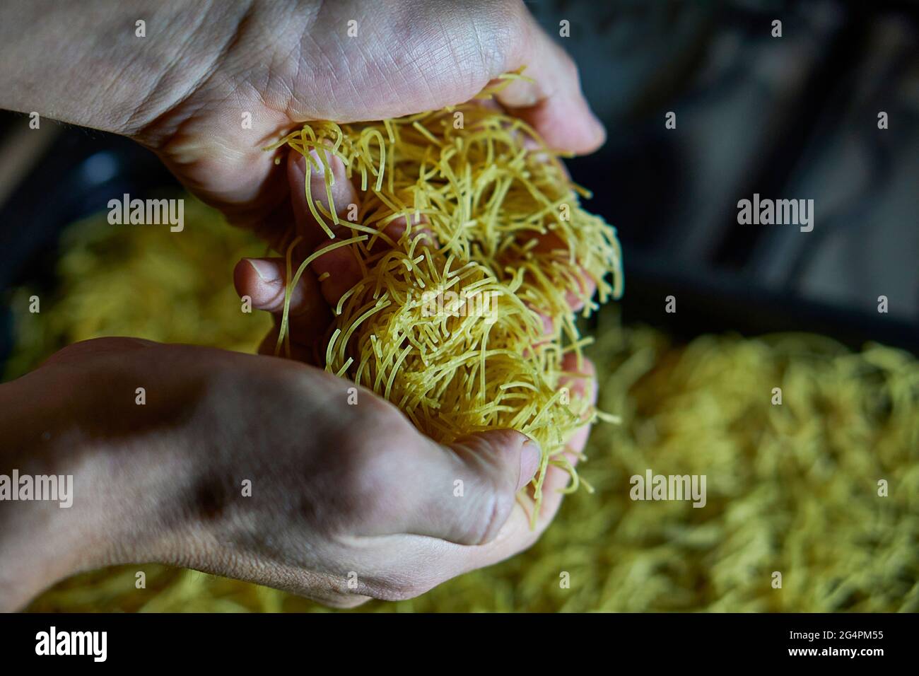 Menschliche Hände Kochen Engel Haar Nudeln roh, Pasta horizontal selektiven Fokus Stockfoto