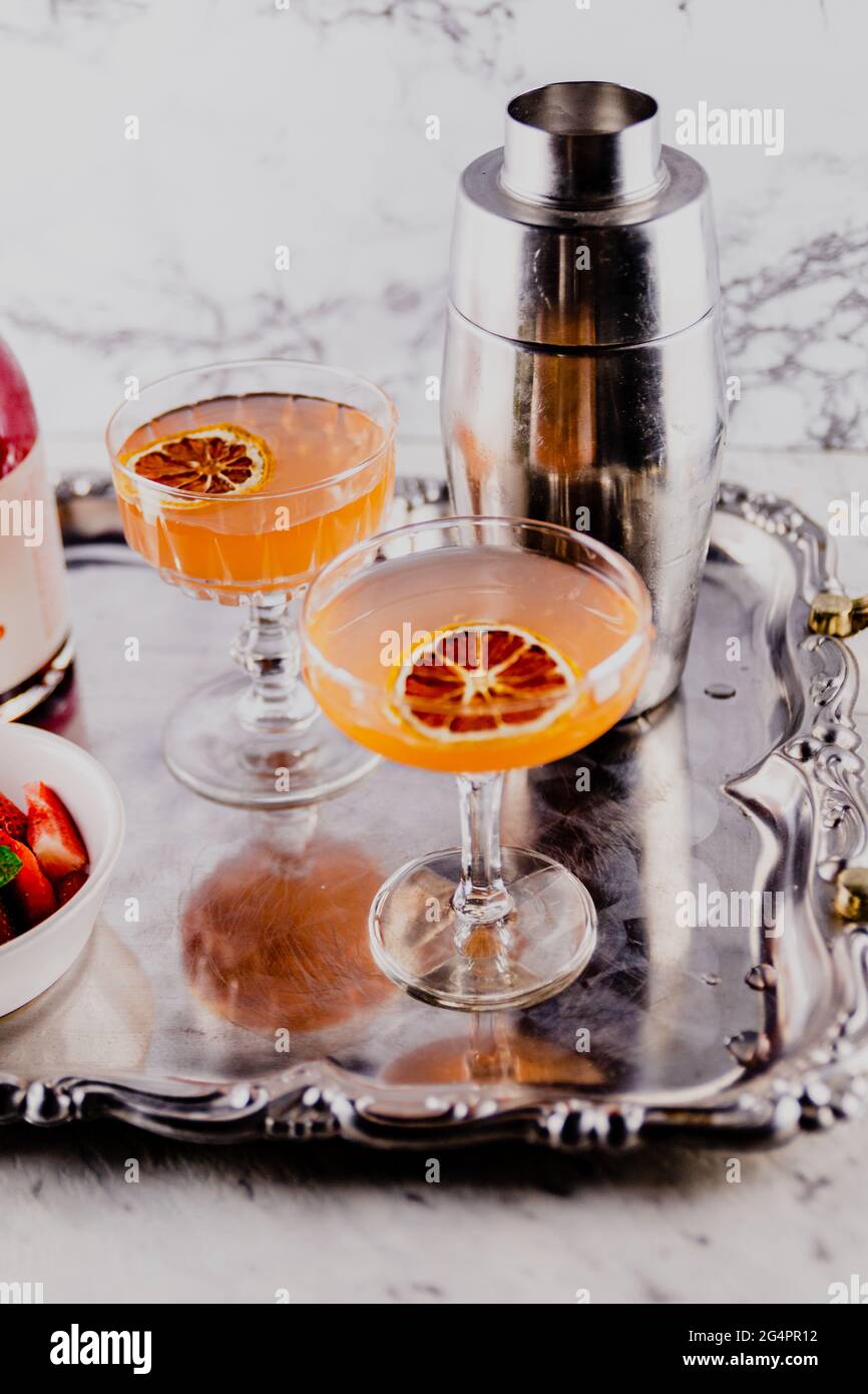 Sommer-Cocktail-Drinks mit Orange und Erdbeere werden auf einem Vintage-Servierteller aus Metall serviert. Stockfoto