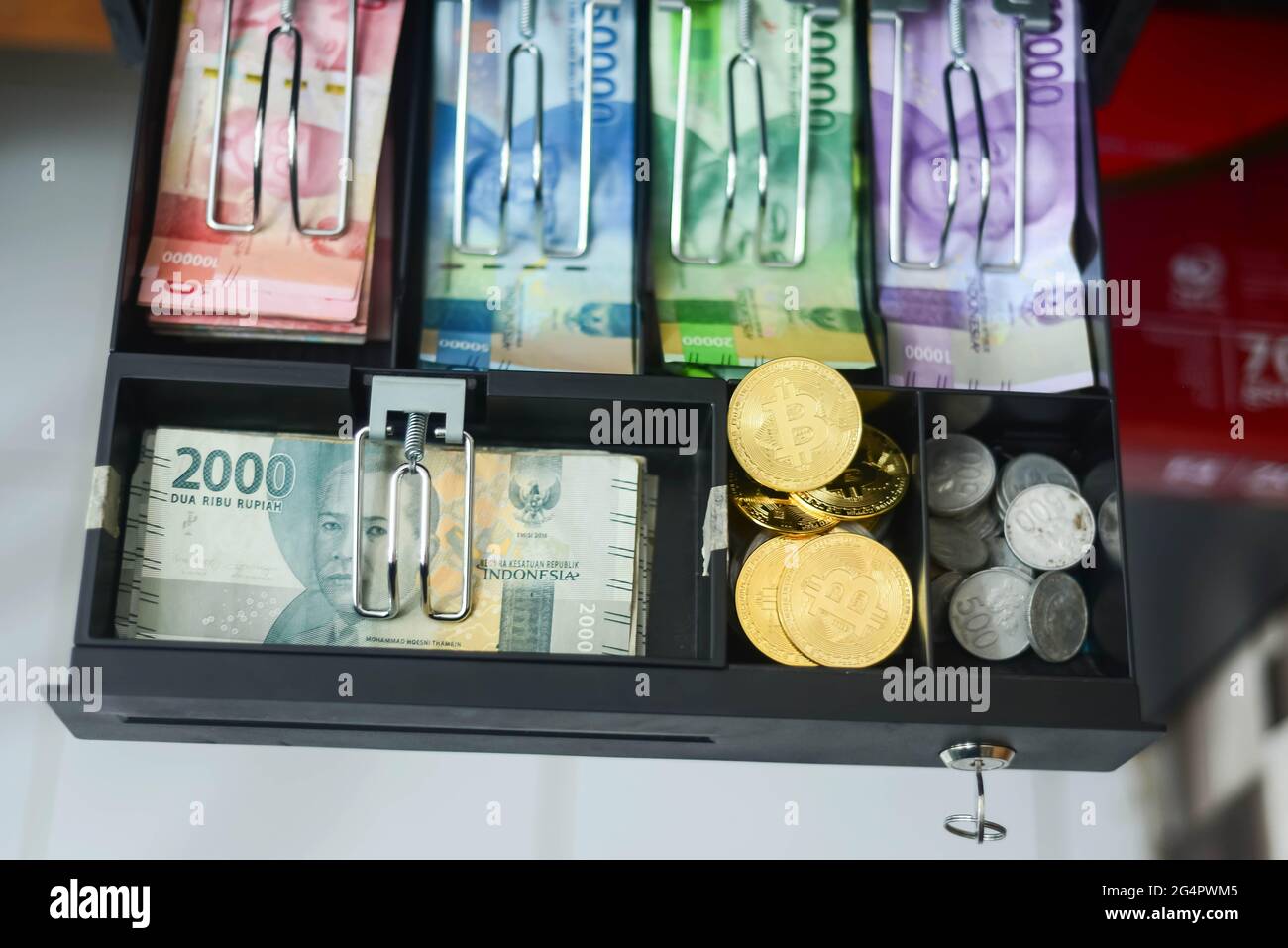 bitcoin und verschiedene Arten indonesischer Rupiah-Konfessionen befinden sich in der Geldschublade, dieses Foto wurde am 23. Juni 2021 aufgenommen Stockfoto