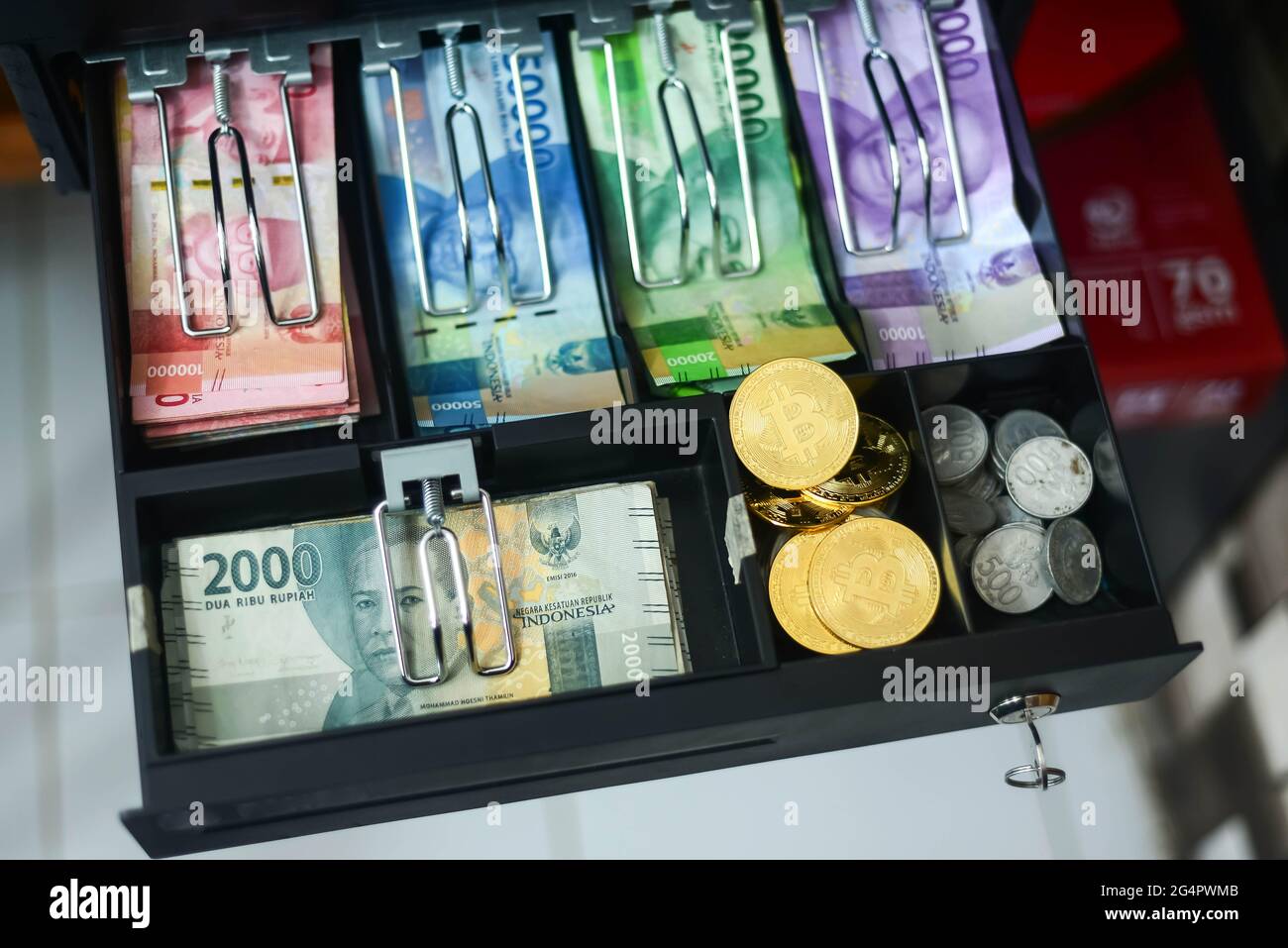 bitcoin und verschiedene Arten indonesischer Rupiah-Konfessionen befinden sich in der Geldschublade, dieses Foto wurde am 23. Juni 2021 aufgenommen Stockfoto