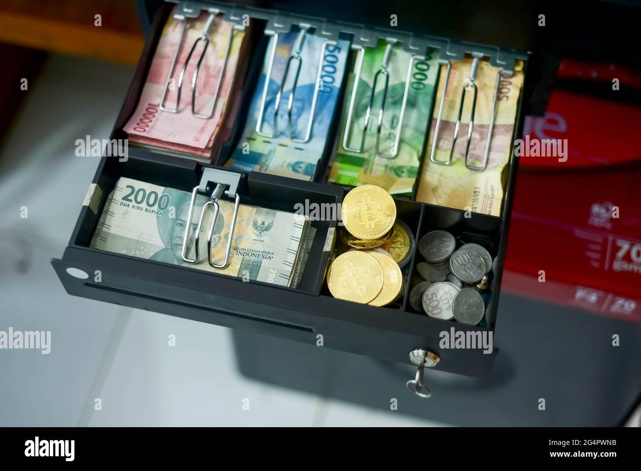 bitcoin und verschiedene Arten indonesischer Rupiah-Konfessionen befinden sich in der Geldschublade, dieses Foto wurde am 23. Juni 2021 aufgenommen Stockfoto