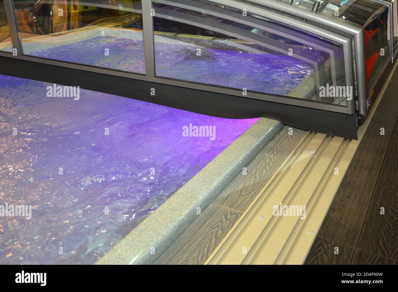 Eine Nahaufnahme einer niedrig einschiebbaren Polycarbonat-Schwimmbadabdeckung, Schiebebecken im Freien. Stockfoto