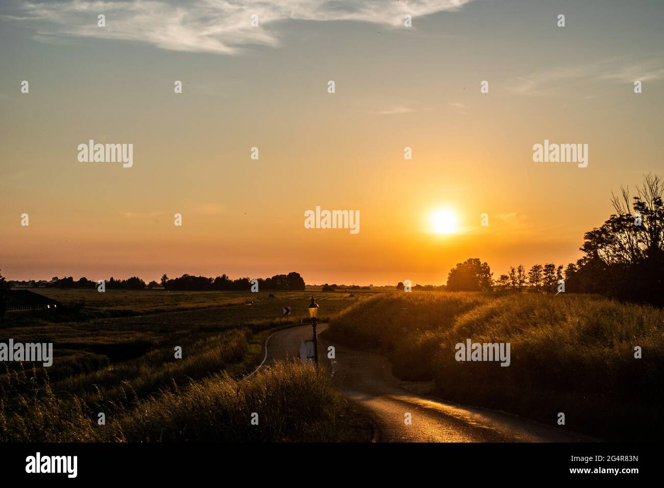 Sonnenuntergang über einem Grasfeld in Uitdam, Niederlande Stockfoto