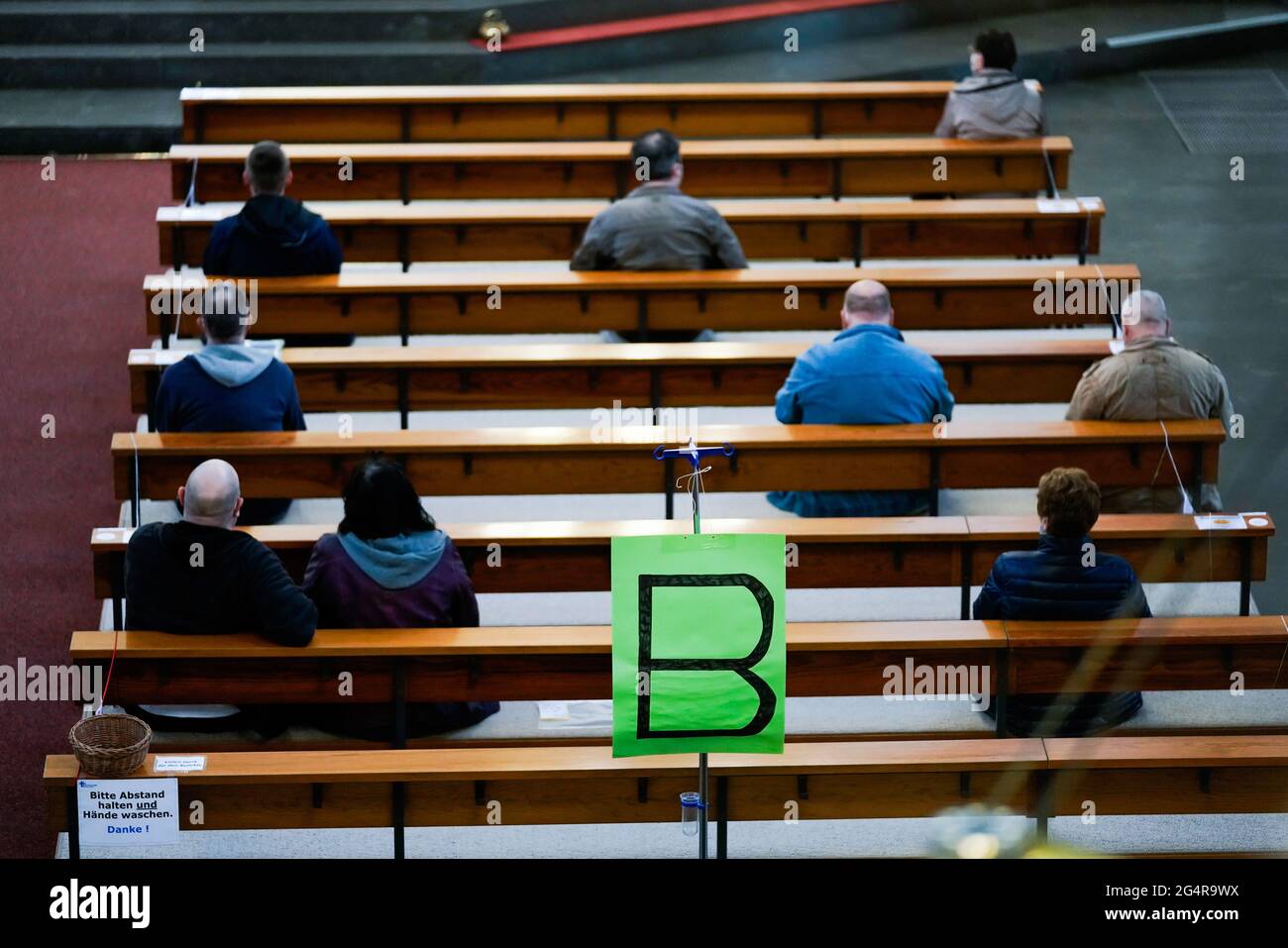 In der katholischen Kirche St. Antonius in Castrop-Rauxel können sich am Mittwoch (19.05.2021) Patienten einer benachbarten Arztpraxis gegen Corona impfen lassen. (Foto: Wartebereich auf den Kirchenbänken). Bis zu 60 Menschen pro Stunde sollen eine Corona-Schutzimpfung erhalten. Die Kirche ist damit eine der bundesweit ersten, die sich für eine solche Aktion zur Verfügung gestellt hat. Stockfoto