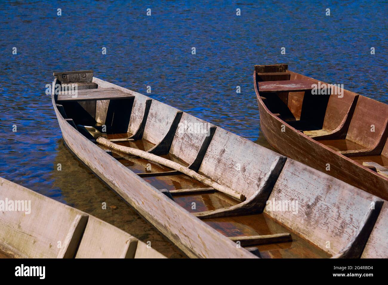 Traditionelles Angeln mit flachen Holzbooten am Flussufer, ländliche Landschaft Stockfoto