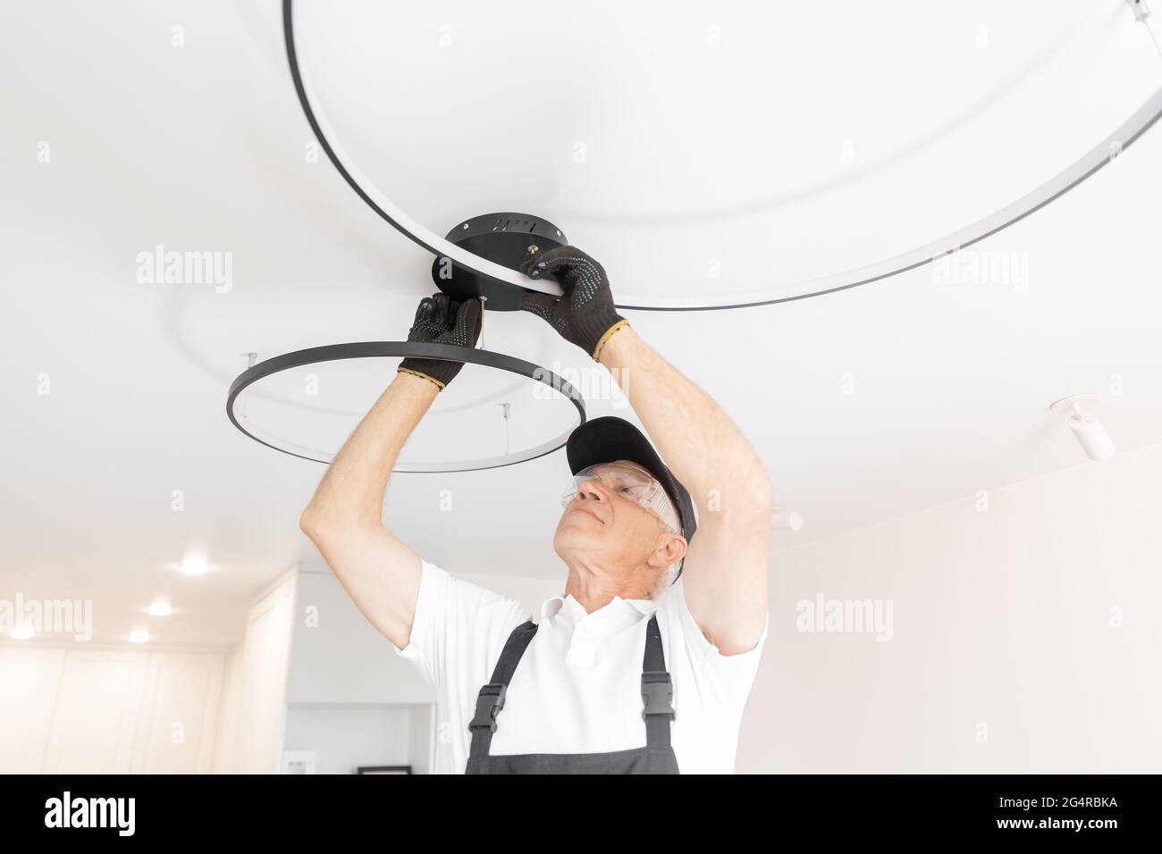 Elektriker Mann Arbeiter installieren Lampe Beleuchtung und Spot Loft-Stil  an der Decke in der Wohnung oder im Büro Stockfotografie - Alamy