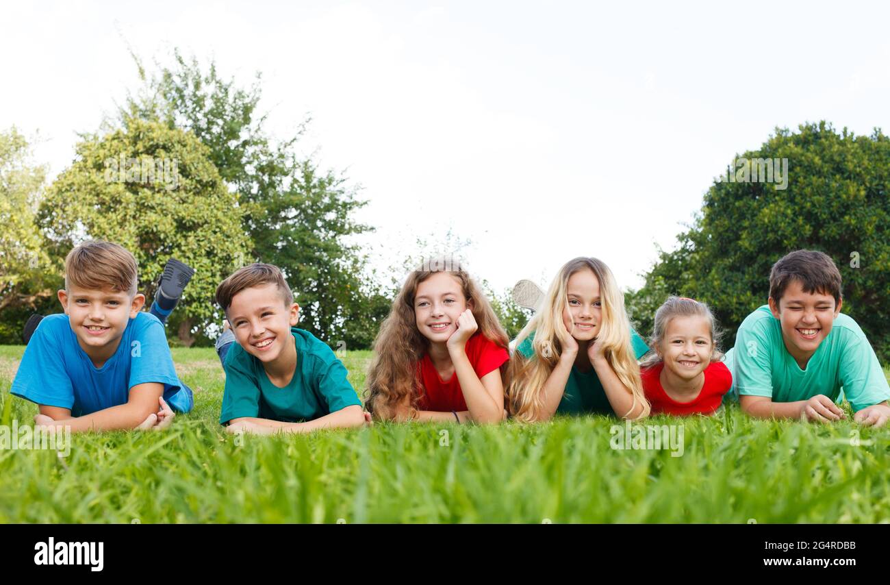 Glückliche Kinder liegen im Park Stockfoto