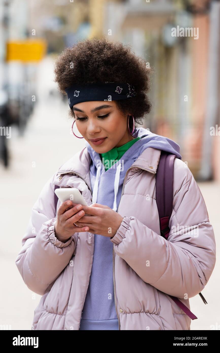 Stilvolle afroamerikanische Frau mit Smartphone im Freien Stockfoto