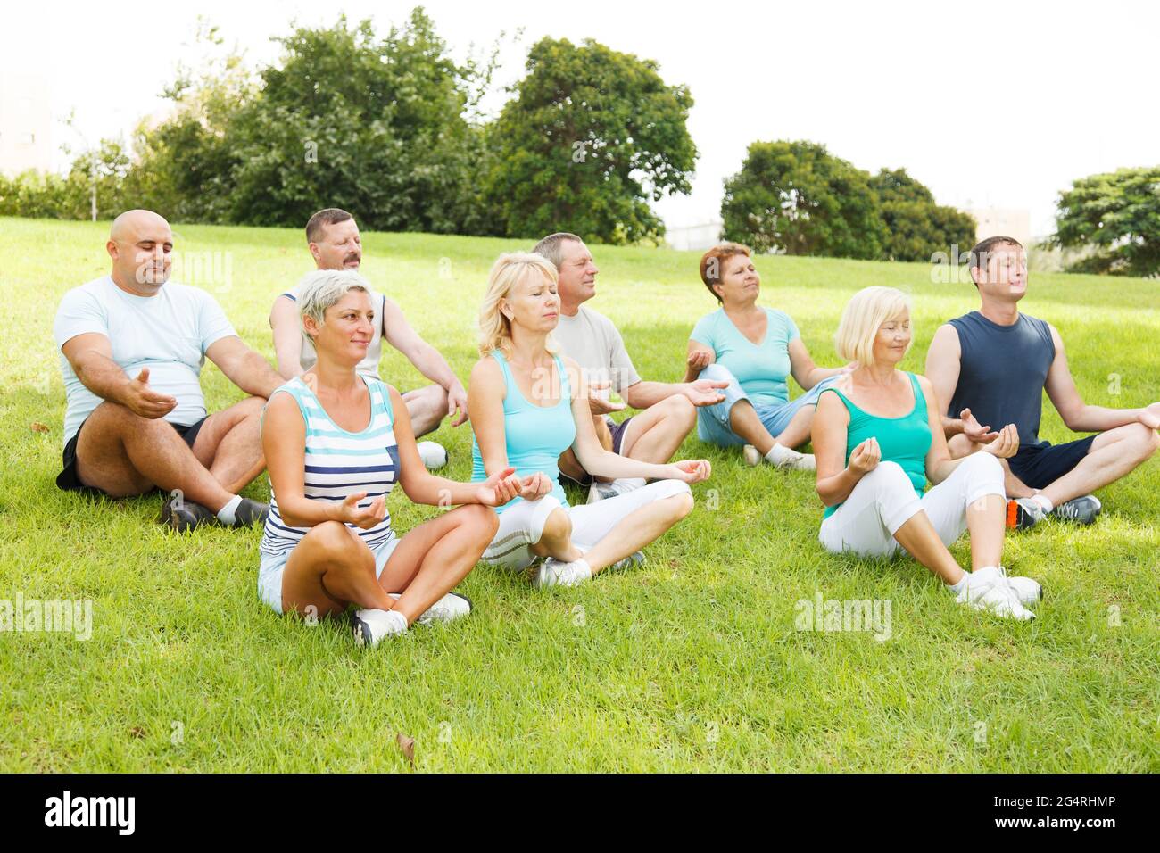 Gruppe von Menschen, die draußen Yoga praktizieren Stockfoto