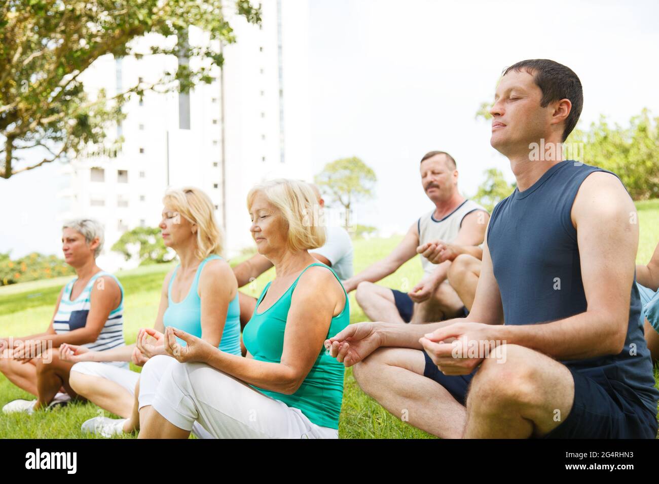 Gruppe von Menschen, die draußen Yoga praktizieren Stockfoto