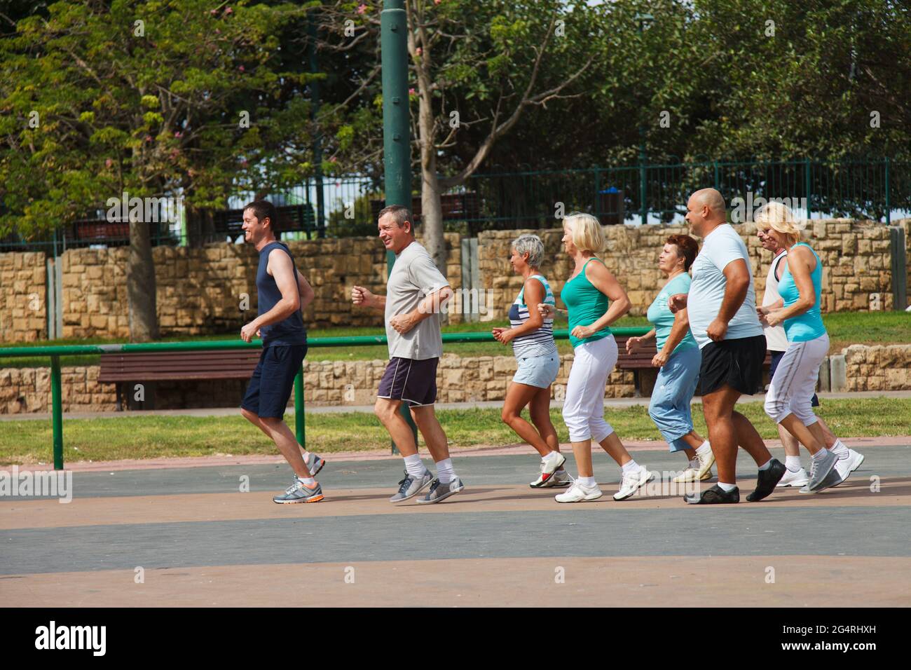 Acht Personen joggen an einem schönen Tag im Park Stockfoto