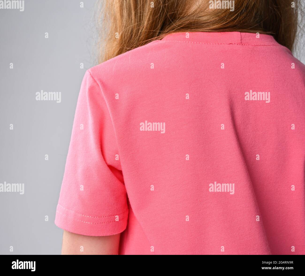Nahaufnahme des rothaarigen Mädchen rosa T-Shirt Schulter, Ärmel und Rücken. Rückansicht. Sommerkleidung Stockfoto
