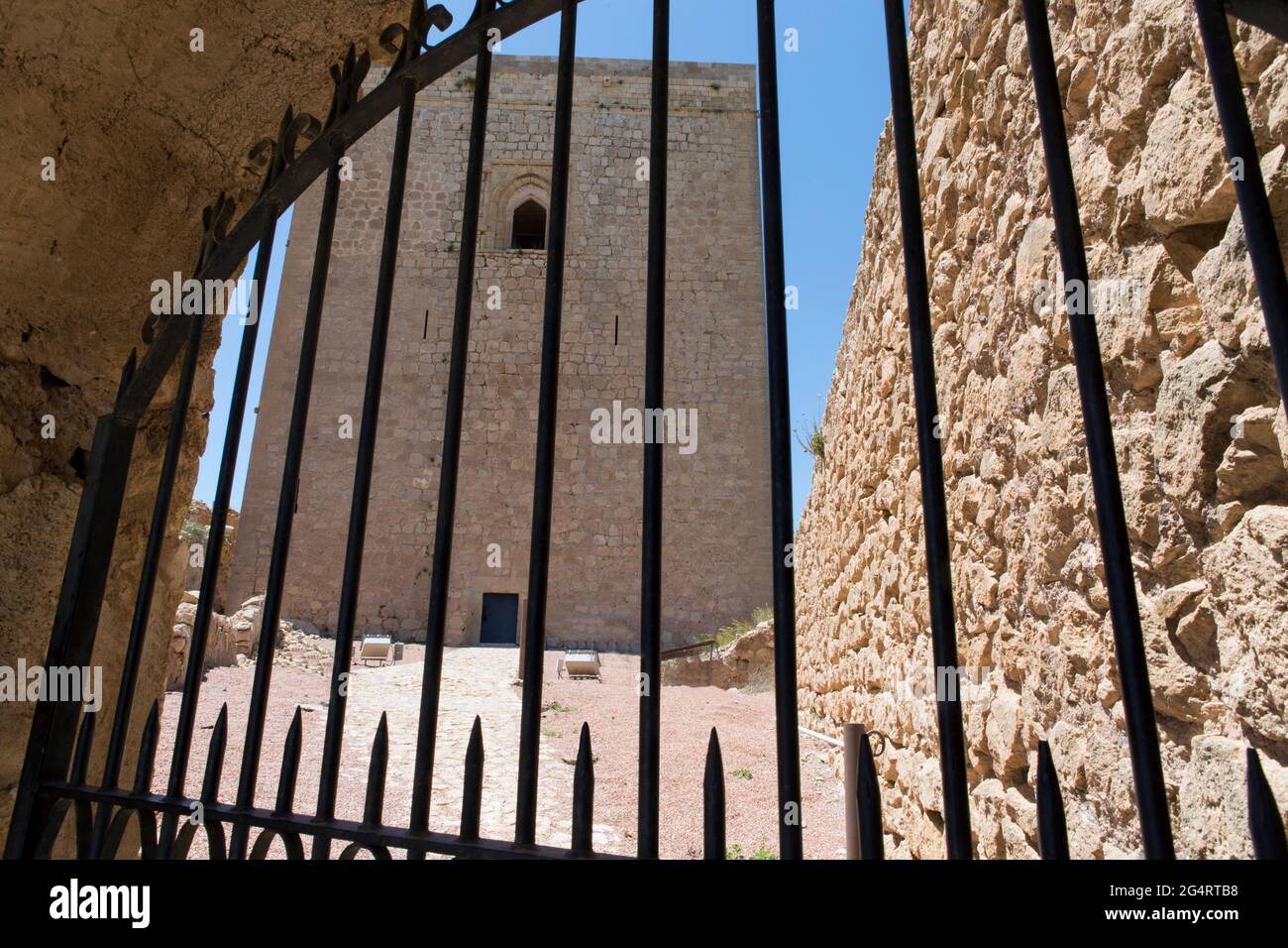 Das Tor ist mit Eisenstangen verschlossen, um den Durchgang zu verhindern und den Turm der mittelalterlichen Burg in Lorca, Murcia, Spanien, zu schützen. Stockfoto