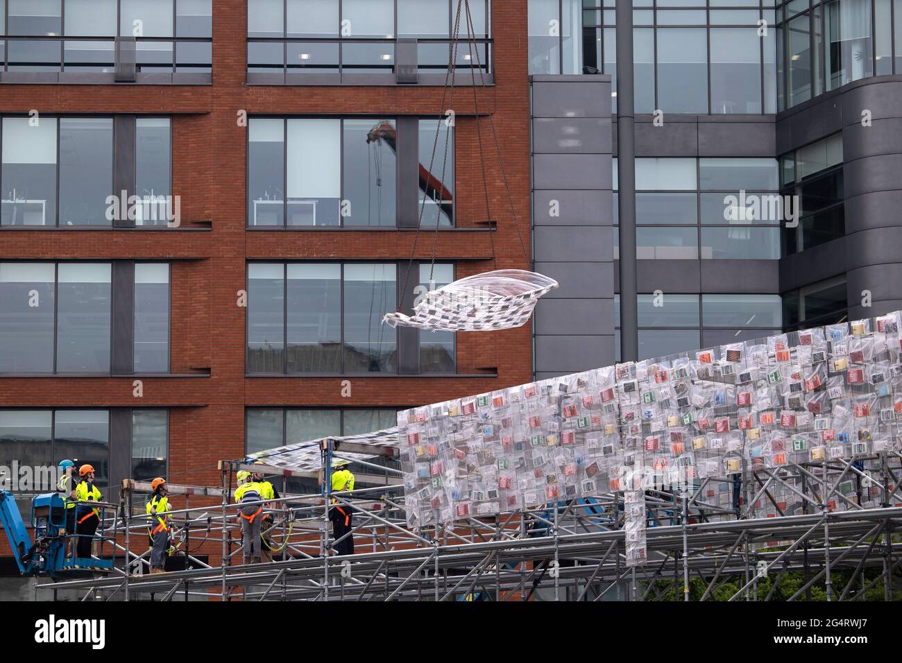 MANCHESTER, Großbritannien die argentinische Künstlerin Marta Minujins riesige partizipative Skulptur 'Big Ben Lying Down with Political Books' - im Auftrag des Manchester International Festival - wird in Piccadilly Gardens montiert. Die 42 Meter lange Skulptur wird in 20,000 Büchern behandelt, die den politischen Diskurs in Großbritannien geprägt haben. Dazu gehören Bücher von Marcus Rashford, David Baddiel, Lemn Sissay und Rutger Bregman. Am Ende des Festivals werden die Bücher an die Öffentlichkeit vergeben. Mittwoch, 23. Juni 2021. (Kredit: Pat Scaasi, Mi News) Kredit: MI Nachrichten & Sport /Alamy Live Nachrichten Stockfoto