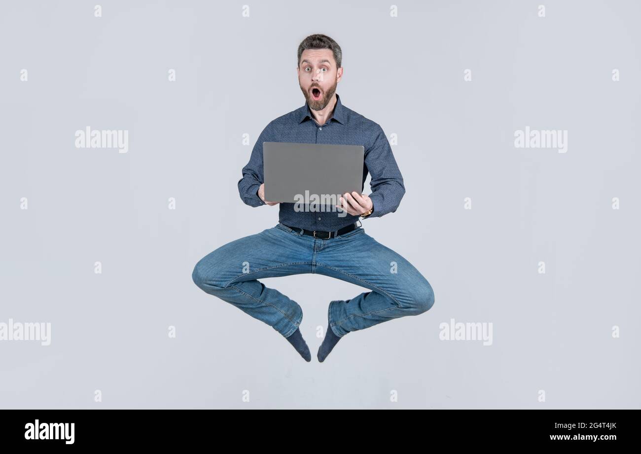 Überrascht energisch springenden Mann Geschäftsmann während der Arbeit online auf Laptop, Verkauf Stockfoto
