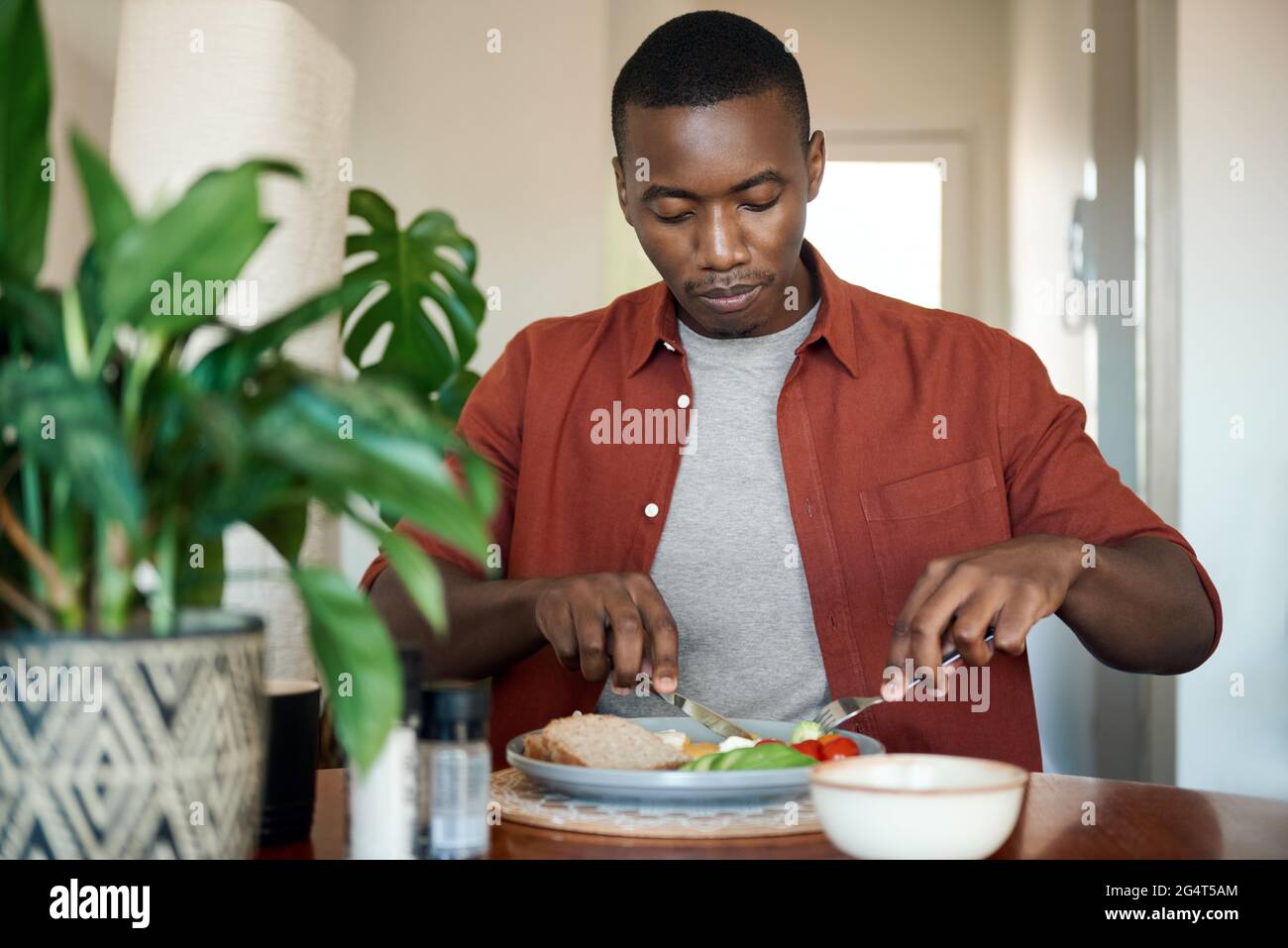 Junger afrikanischer Mann genießt ein hausgemachtes Frühstück Stockfoto