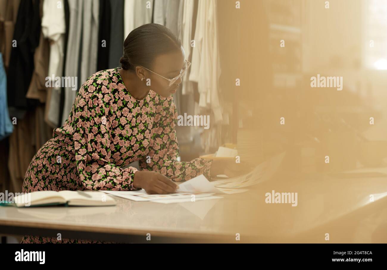 Afrikanische weibliche Modedesignerin, die in ihrem Studio Farbmuster ansieht Stockfoto