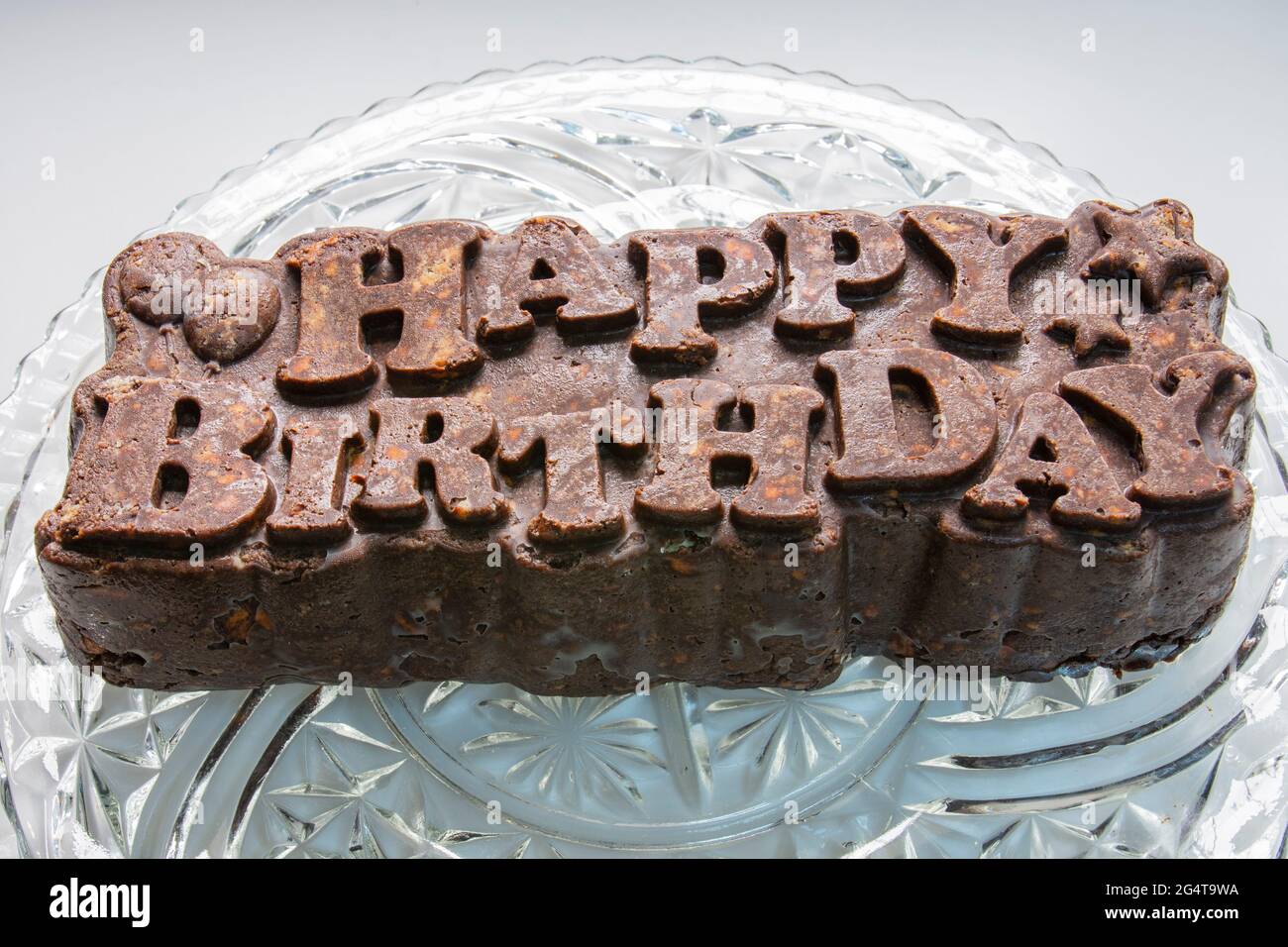 Abschließen. Sie macht einen Geburtstagskuchen mit Keksen und Schokolade. Mosaikkuchen. Alles Gute zum Geburtstag. Stockfoto