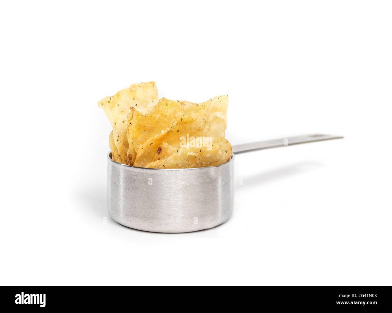 Kartoffelchips im Messbecher. Perspektivische Ansicht von Chips mit Kräutergeschmack in einem Edelstahlbehälter. Konzept für die Portionskontrolle oder die Zubereitung von Mahlzeiten. Isol Stockfoto